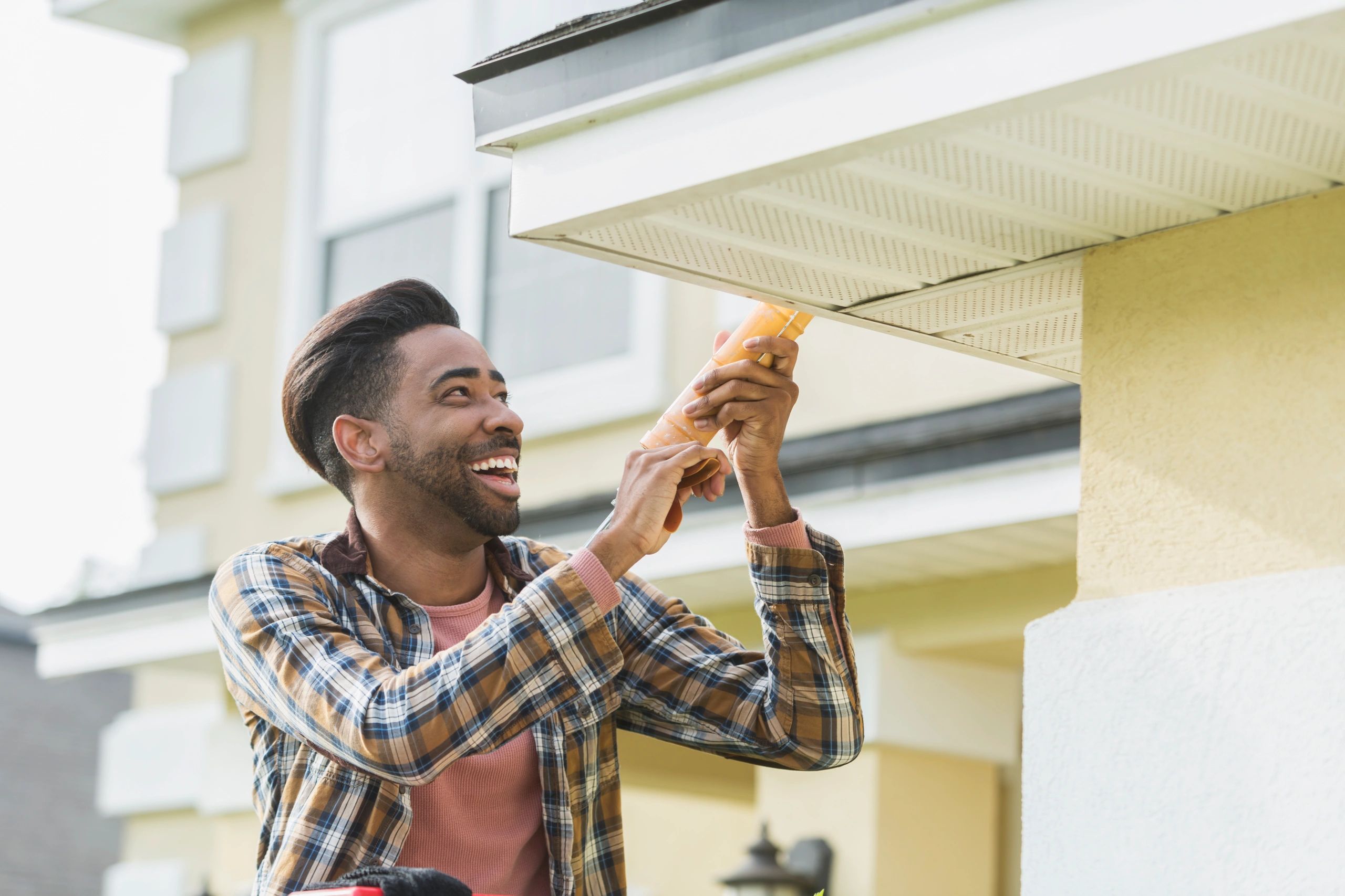 Handyman on ladder outside a home